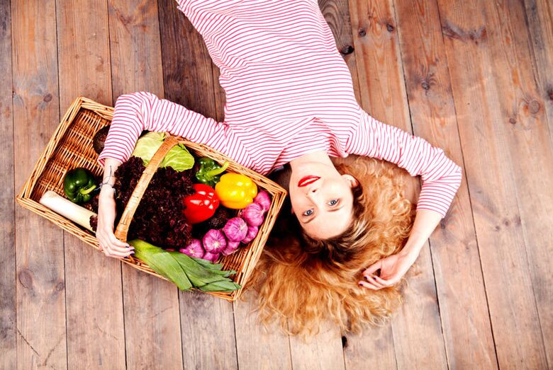 Fille avec un panier plein de légumes